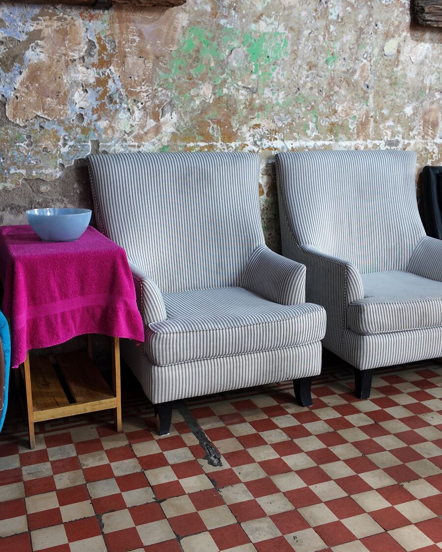 Sala de espera con sillones y pared de piedra